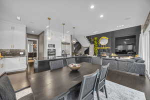 Dining room with sink, a fireplace, and dark wood-type flooring