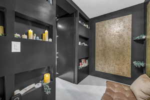 Bathroom with built in shelves and concrete floors