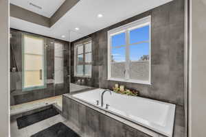 Bathroom featuring tile patterned flooring and separate shower and tub