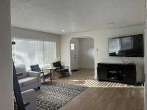 Living room featuring a textured ceiling and hardwood / wood-style flooring