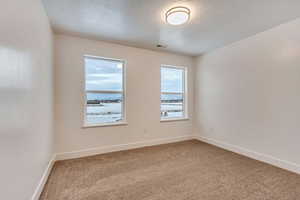 Carpeted empty room with a textured ceiling