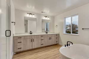 Bathroom featuring hardwood / wood-style floors, a bathtub, a textured ceiling, and vanity