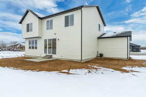 Snow covered house featuring central AC unit