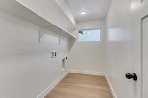 Washroom featuring hookup for an electric dryer, hookup for a washing machine, and light hardwood / wood-style flooring