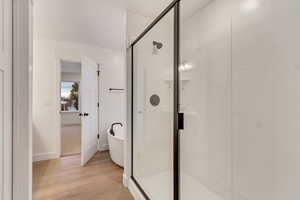 Bathroom featuring hardwood / wood-style floors and separate shower and tub