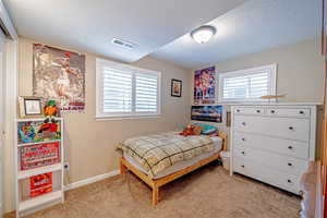 Carpeted bedroom featuring a textured ceiling