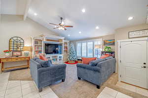 Tiled living room with vaulted ceiling with beams and ceiling fan