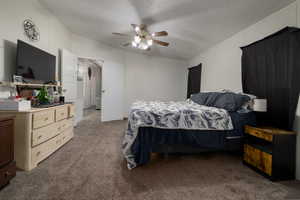 Carpeted bedroom with ceiling fan and a textured ceiling