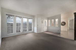 Interior space featuring carpet and a textured ceiling