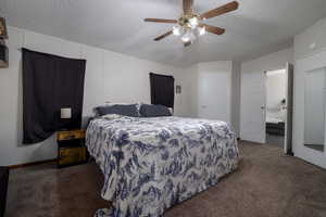 Bedroom with carpet, a textured ceiling, ceiling fan, and connected bathroom