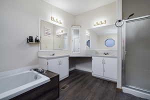 Bathroom featuring a bathtub, vanity, wood-type flooring, and a textured ceiling