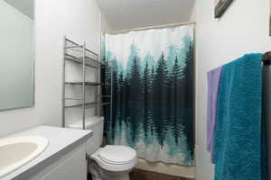 Bathroom with tile patterned floors, vanity, a textured ceiling, and toilet