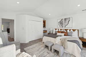 Freshly carpeted and painted guest bedroom with lofted ceiling and a closet