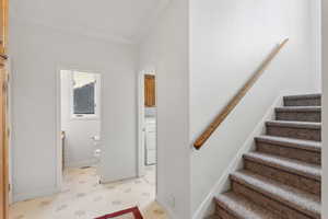 Main floor mud room from garage with access to powder half bathroom and laundry room with additional stairway to the second floor