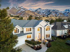 View of front of house with a mountain view, a garage, and a lawn