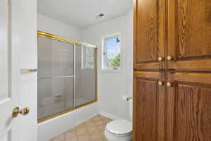 Full Bathroom with tile patterned floors, vanity, and toilet and built in storage