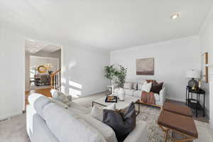 Freshly carpeted and painted living room with a tile fireplace and ornamental molding