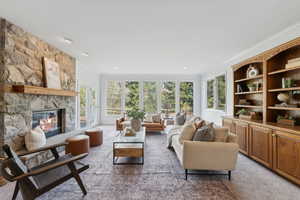 Freshly carpeted and painted family room with floor to ceiling windows, walk out to deck, stone fireplace and built ins.