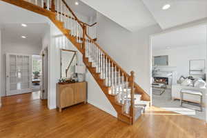 Stairs to second floor with hardwood / wood-style floors