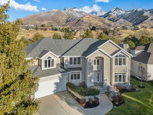 View of front facade with a mountain view, a garage, and a front lawn