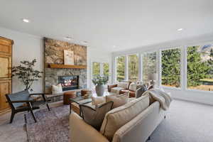 Freshly carpeted and painted family room with floor to ceiling windows, walk out to deck, stone fireplace and built ins.