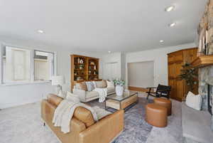 Freshly carpeted and painted family room with floor to ceiling windows, walk out to deck, stone fireplace and built ins.