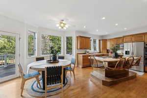 Kitchen with sink, light hardwood / wood-style flooring, ornamental molding, and appliances with stainless steel finishes and walk out to deck