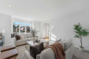 Freshly carpeted and painted living room with a tile fireplace and window seat picture window facing west