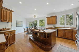 Kitchen with appliances with stainless steel finishes, light hardwood / wood-style floors, sink, and a wealth of natural light