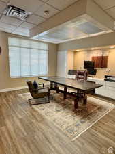 Recreation room with a paneled ceiling and wood-type flooring