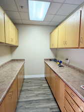 Kitchen with light brown cabinetry, a paneled ceiling, and light hardwood / wood-style flooring