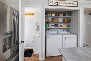 Laundry area featuring hardwood / wood-style floors and washer and dryer