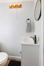 Bathroom featuring vanity, wood-type flooring, and toilet