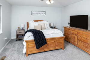 Carpeted bedroom with ceiling fan