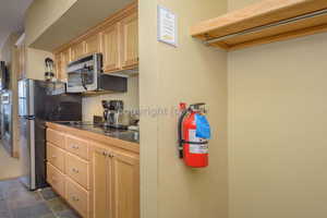 Kitchen featuring tile counters, sink, stainless steel appliances, and light brown cabinetry