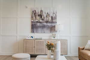 Picture is of model home. Bar featuring white cabinets and light wood-type flooring