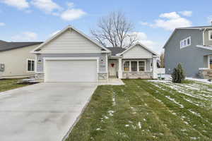 View of front facade with covered porch, a garage, and a front yard