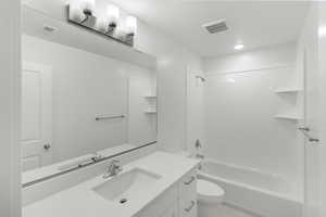 Full bathroom featuring tile patterned flooring, vanity, toilet, and tub / shower combination