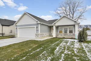 View of front facade featuring a lawn, a mountain view, a porch, and a garage