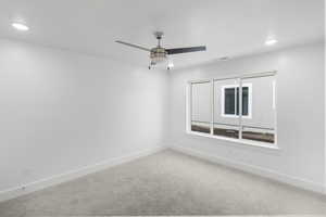 Carpeted empty room featuring ceiling fan