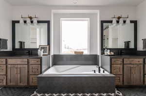 Bathroom with tiled tub and vanity