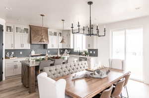 Dining space with a chandelier, a textured ceiling, light hardwood / wood-style floors, and plenty of natural light