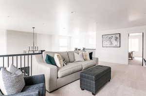 Carpeted living room with a wealth of natural light and a notable chandelier