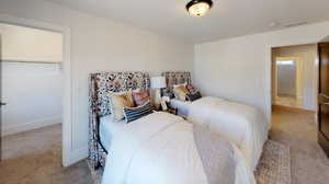 Bedroom featuring light colored carpet, a closet, and a spacious closet