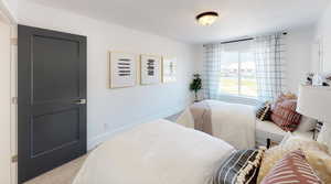 Bedroom with a textured ceiling and light colored carpet