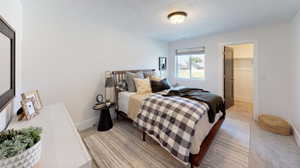 Carpeted bedroom with a walk in closet and a closet