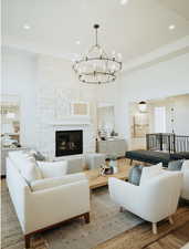 Living area with a chandelier, recessed lighting, a fireplace, and wood finished floors