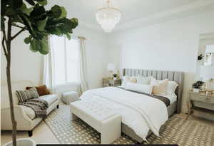 Carpeted bedroom featuring a chandelier and a tray ceiling