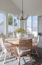 Dining room featuring an inviting chandelier, vaulted ceiling, and a wealth of natural light