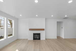 Unfurnished living room with light hardwood / wood-style floors and a wealth of natural light